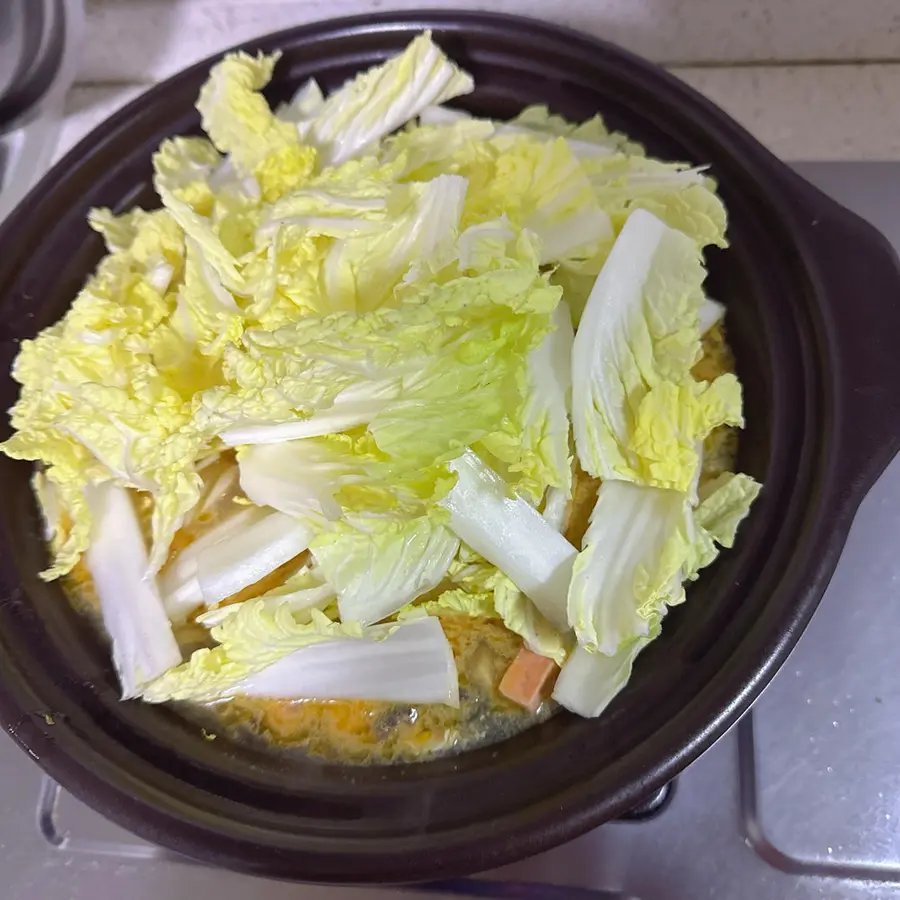 A soup doll dish full of ingredients step 0