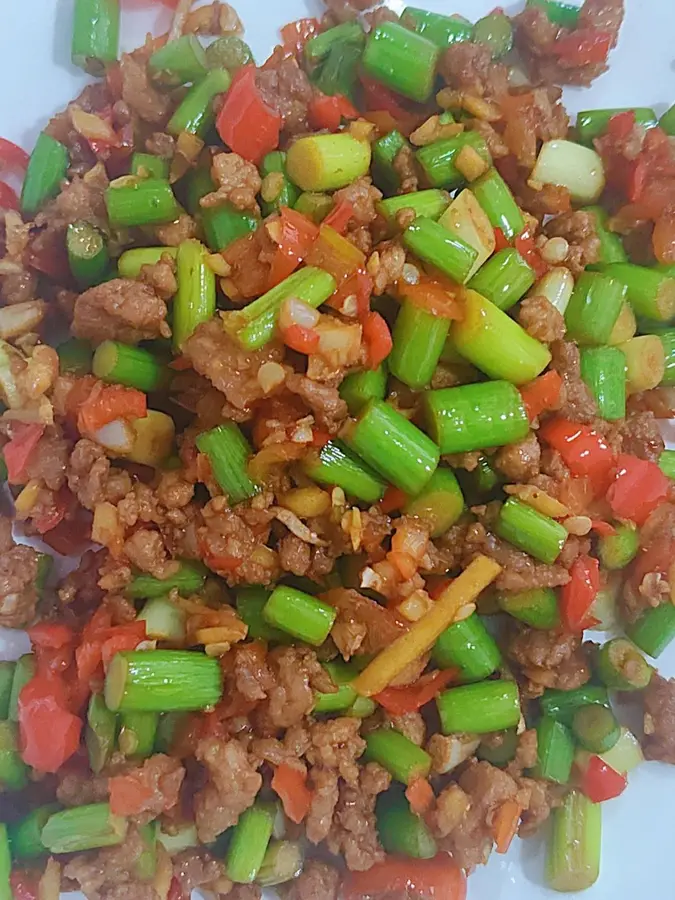 Stir-fry minced pork belly with garlic sprouts and serve as part of the meal step 0