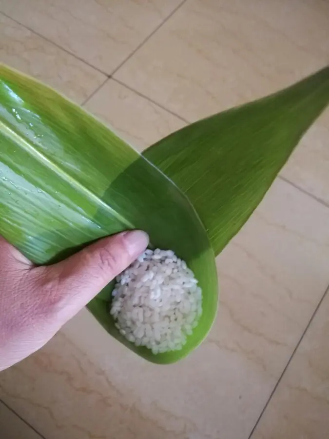 The steps of making zongzi are demonstrated step 0